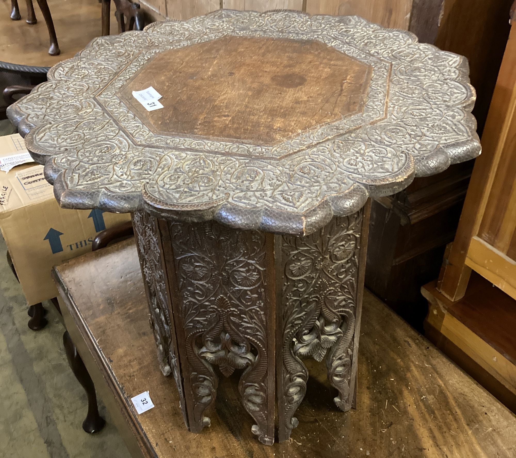 An Indian carved hardwood coffee table on a folding stand, width 63cm height 60cm